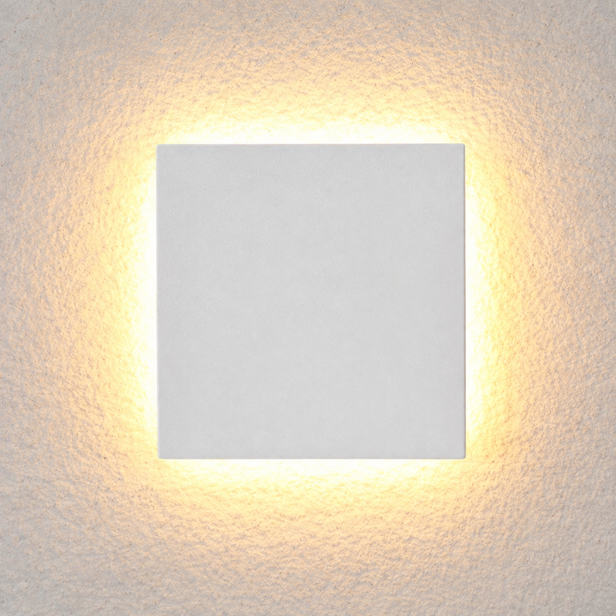 Square white outdoor wall sconce shown at an angle with warm light glowing around the edges.