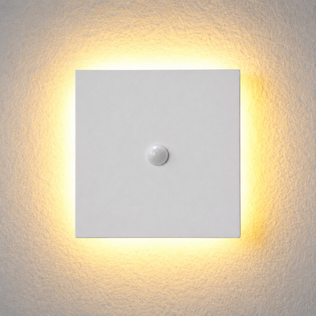 Square white outdoor wall sconce with a central sensor and warm halo on a light wall.