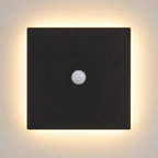 Square black outdoor wall sconce with a central sensor and warm halo on a light wall.