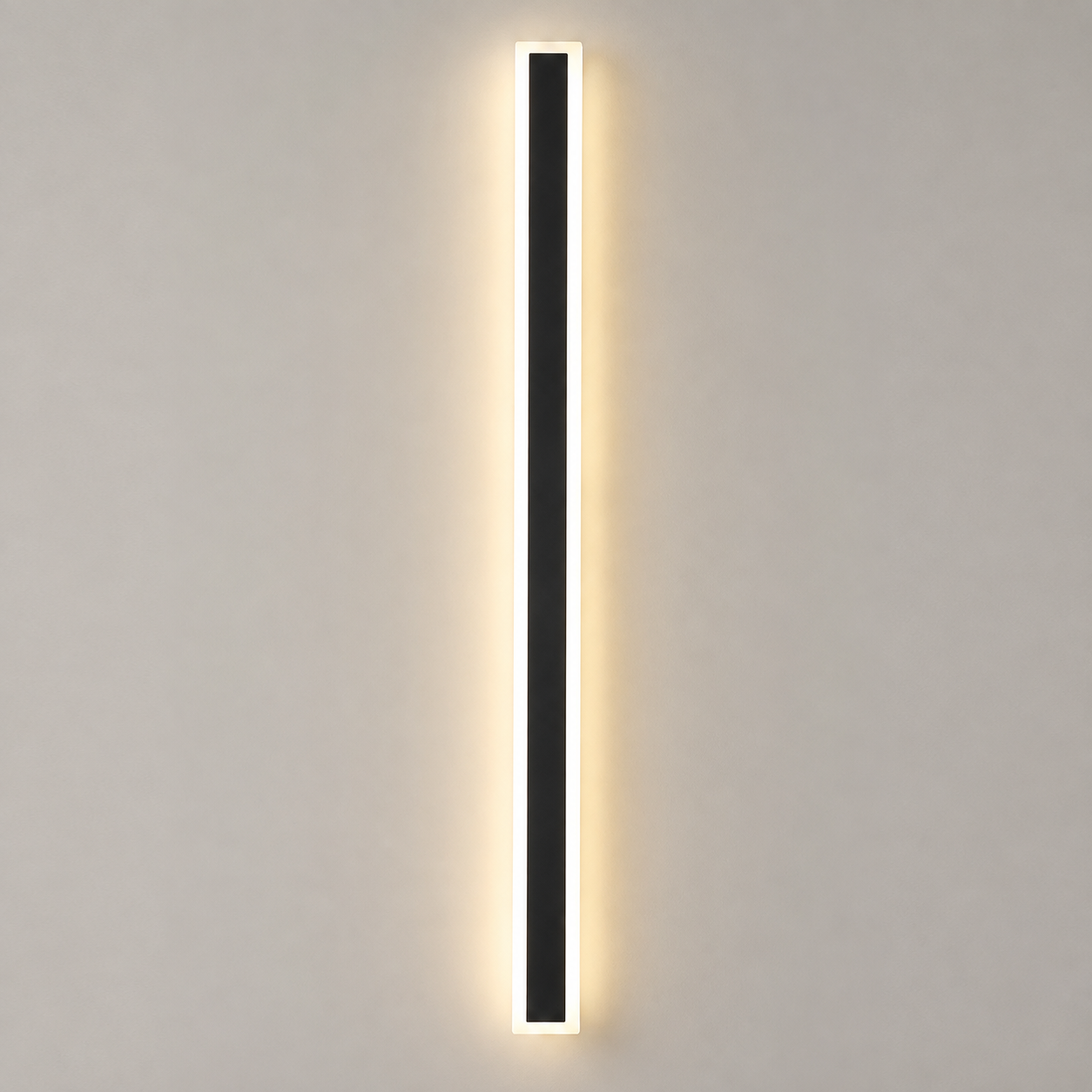 Outdoor wall sconce with a slim black vertical body glowing warm against a light gray wall.