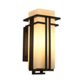 Black outdoor wall sconce with a tall glass shade on a plain background.