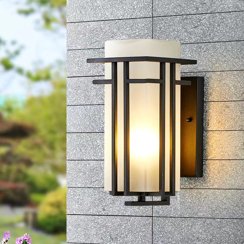 Black outdoor wall sconce mounted on gray exterior masonry.
