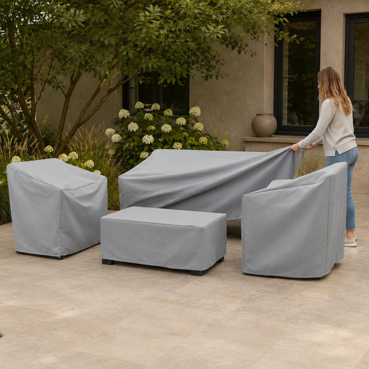 silver patio furniture covers on a full seating set with a person facing away