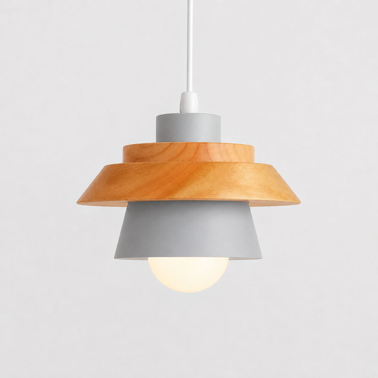 Gray cone pendant light with natural wood accent, glowing against a light gray background.