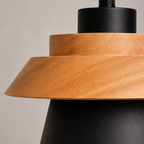 Close-up of pendant light materials showing the wood upper section and aluminum shade.