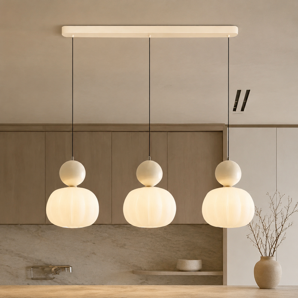 three beige Bauhaus pendant light fixtures over a kitchen island