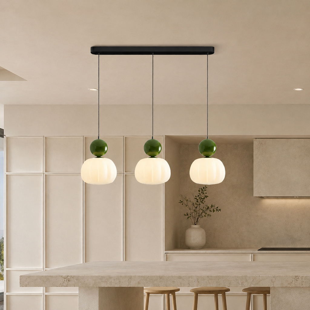 three green Bauhaus pendant light fixtures over a bright kitchen island