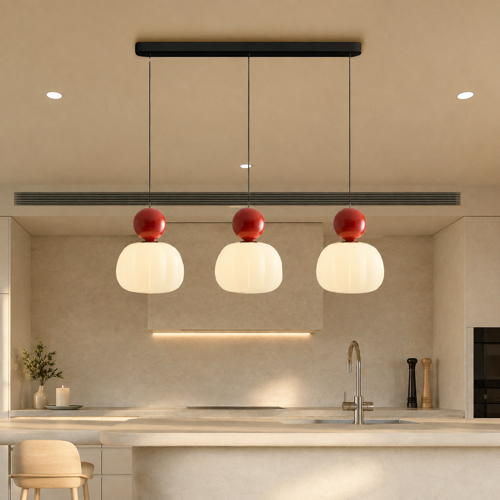 three red Bauhaus pendant light fixtures above a pale counter