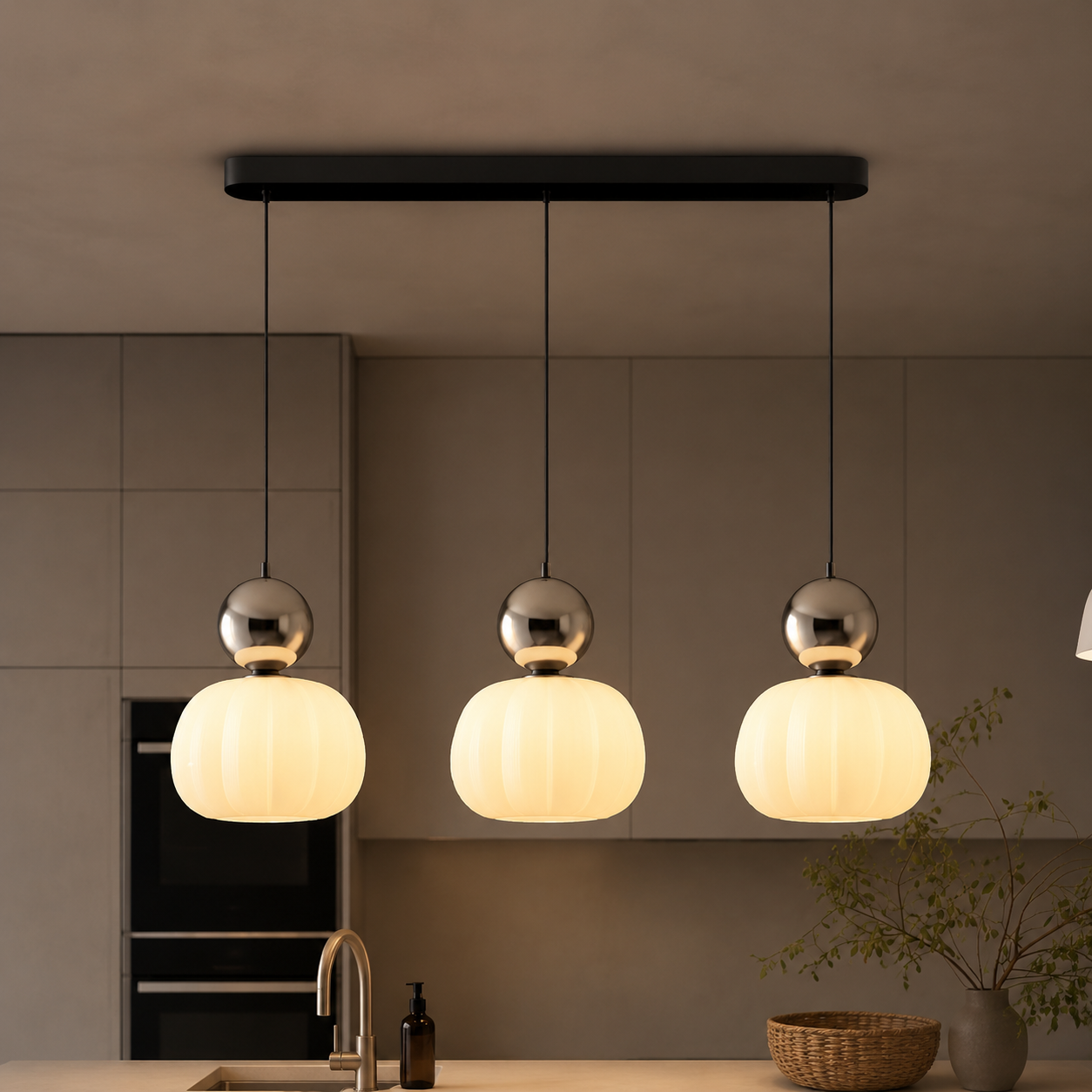 three silver Bauhaus pendant light fixtures in a dark kitchen