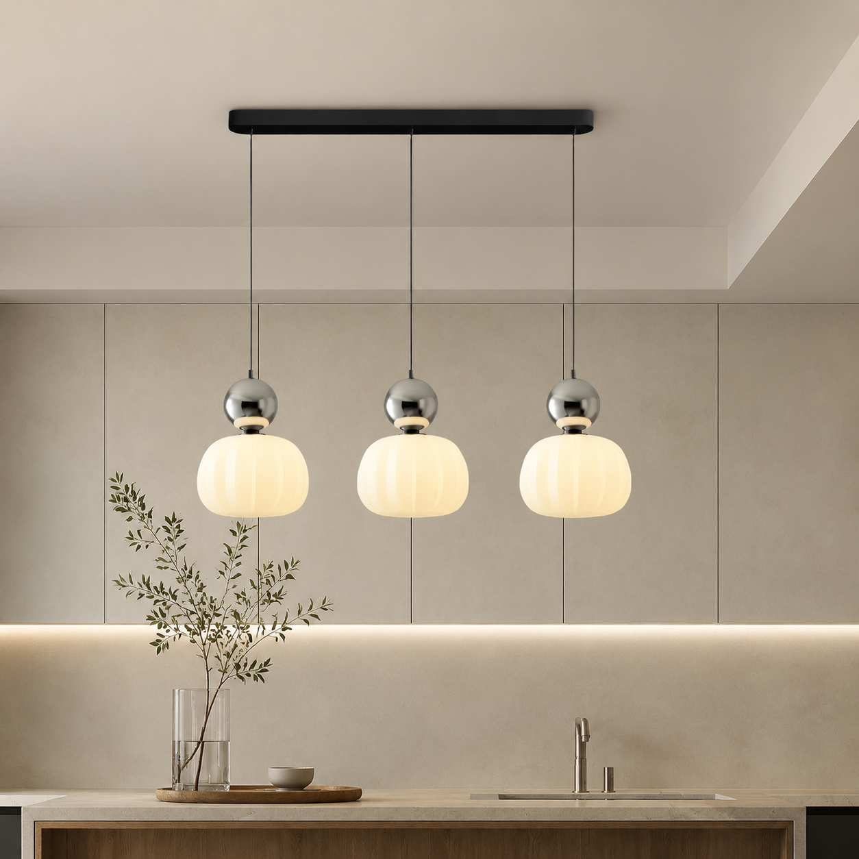three silver Bauhaus pendant light fixtures over a bright backsplash