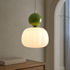 single green Bauhaus pendant light beside an arched window