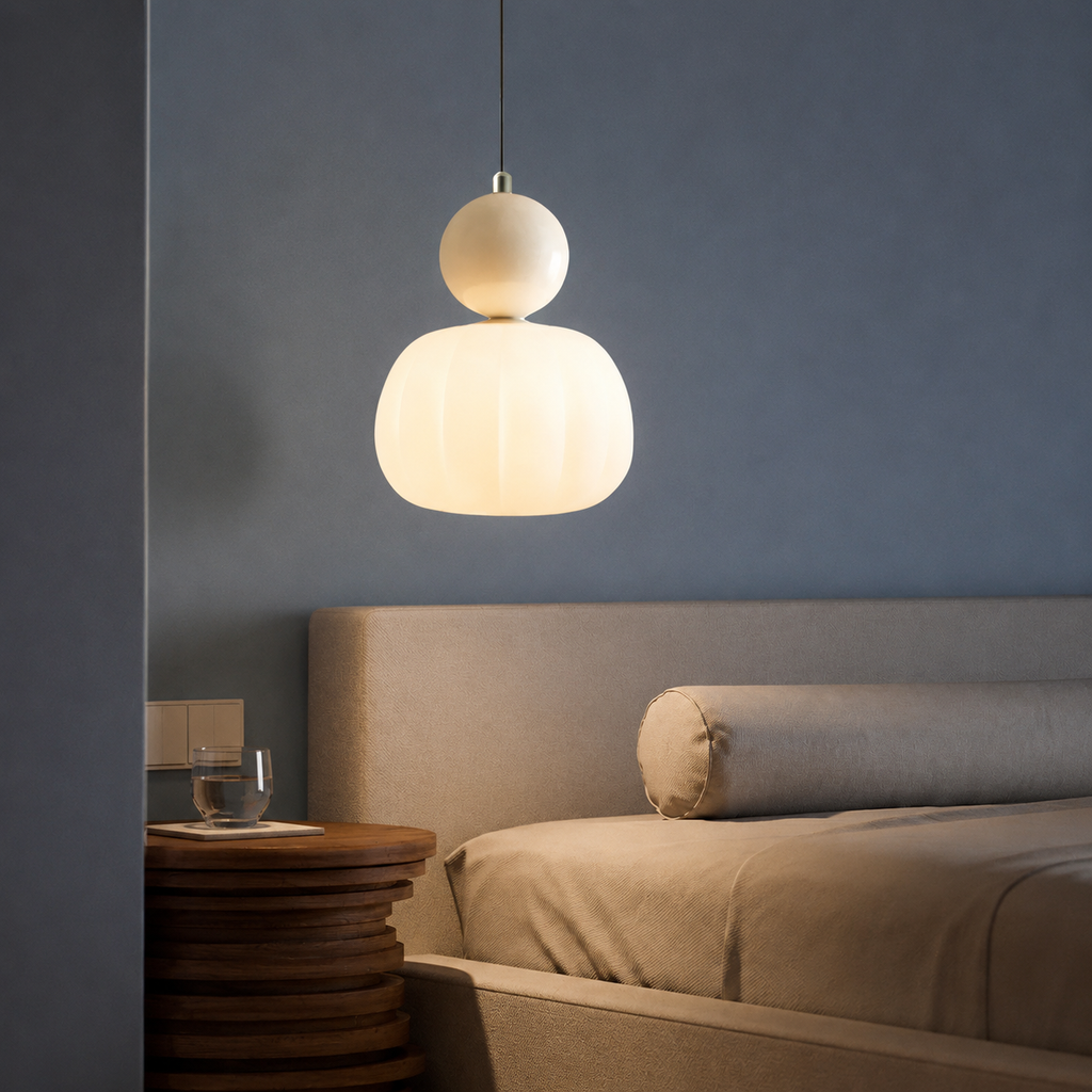 single beige Bauhaus pendant light glowing above a bedroom table