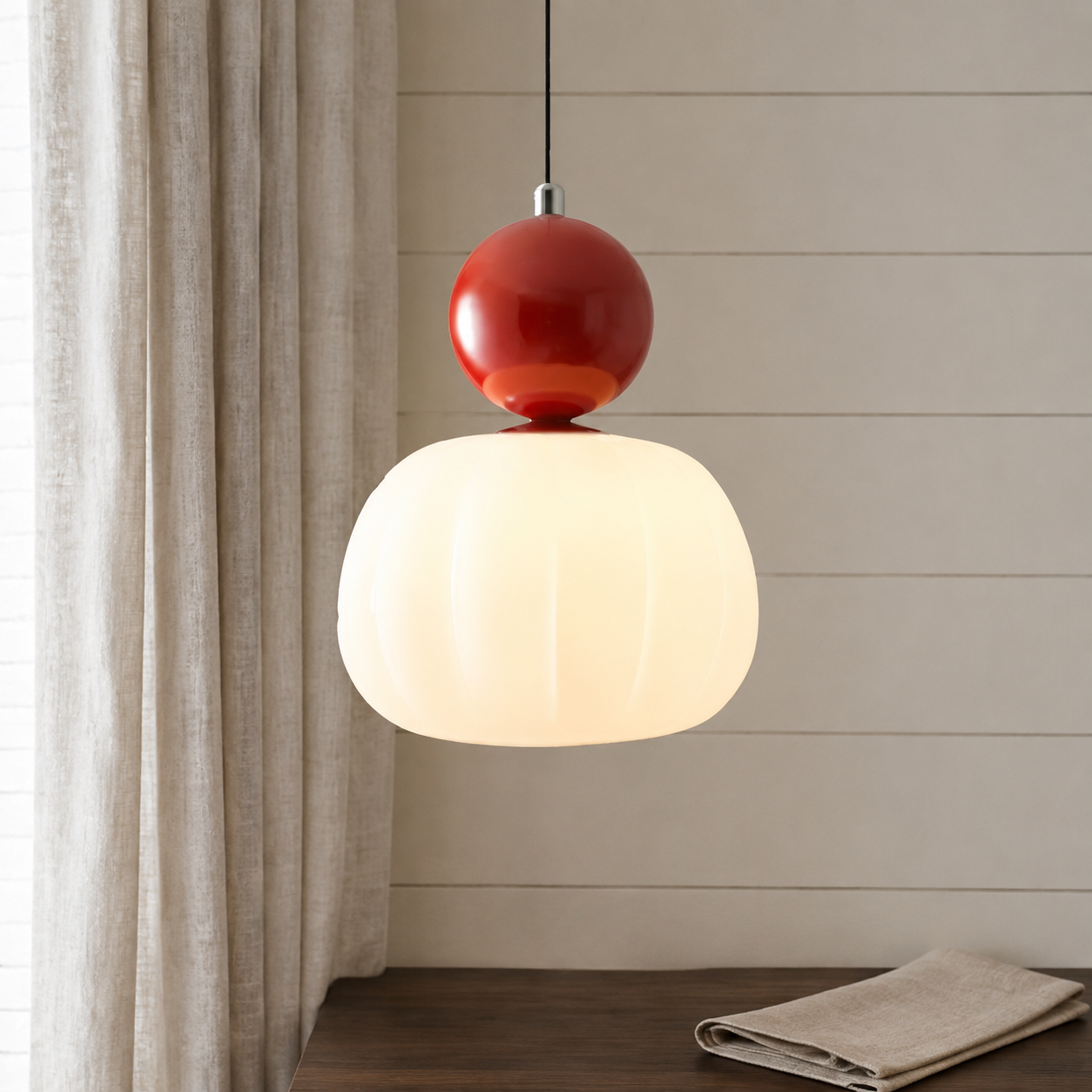 single red Bauhaus pendant light beside ivory curtains