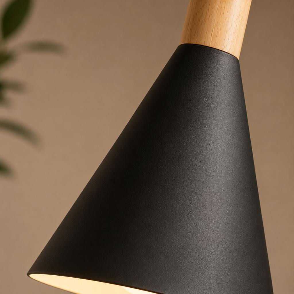 Close-up of a black conical pendant light showing the textured metal shade and natural wood stem.

