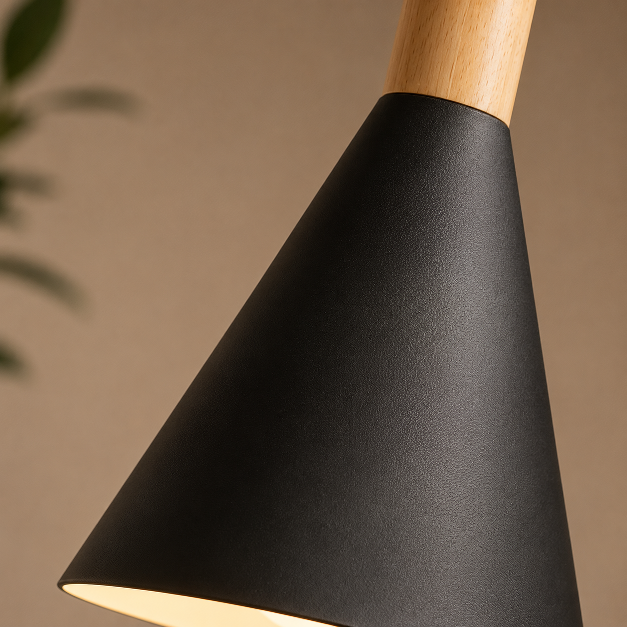 Close-up of a black conical pendant light showing the textured metal shade and natural wood stem.
