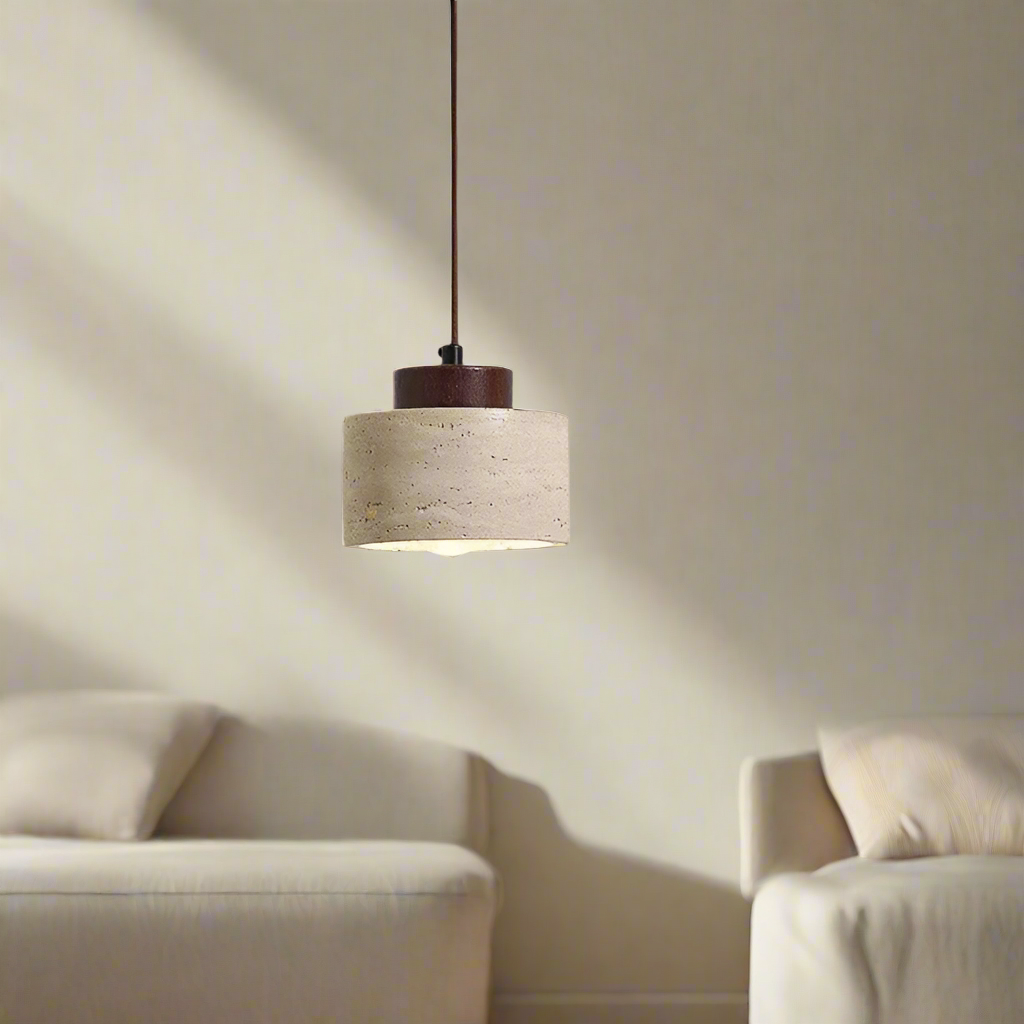 Pendant light with natural stone drum shade and dark walnut toned accent in a living space