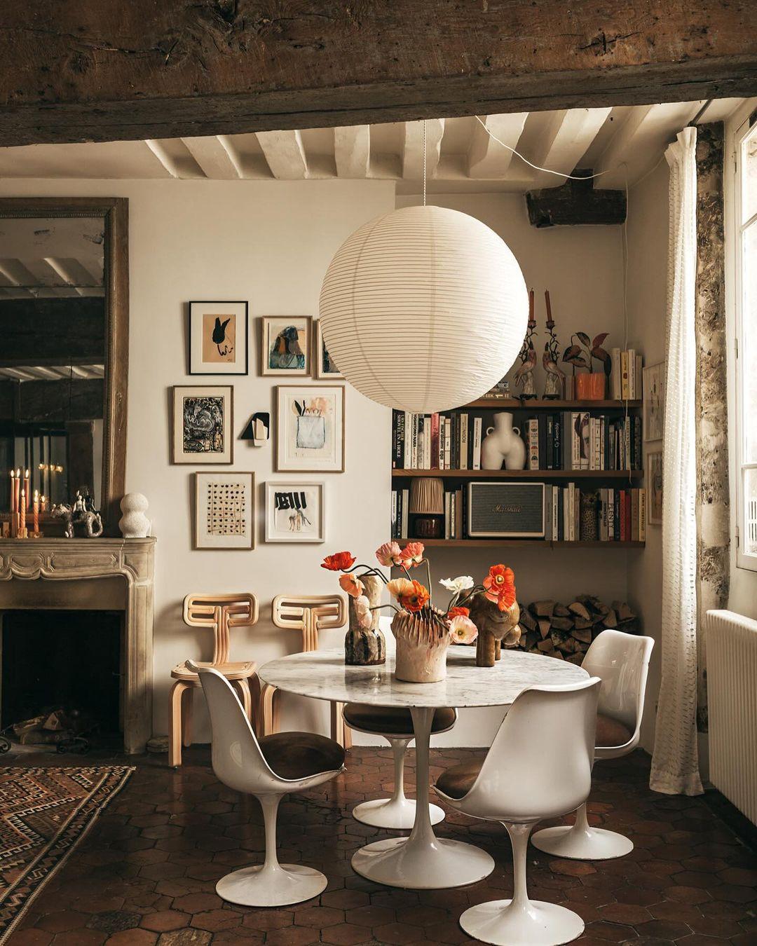 White paper globe pendant light hanging above a furnished living or dining space