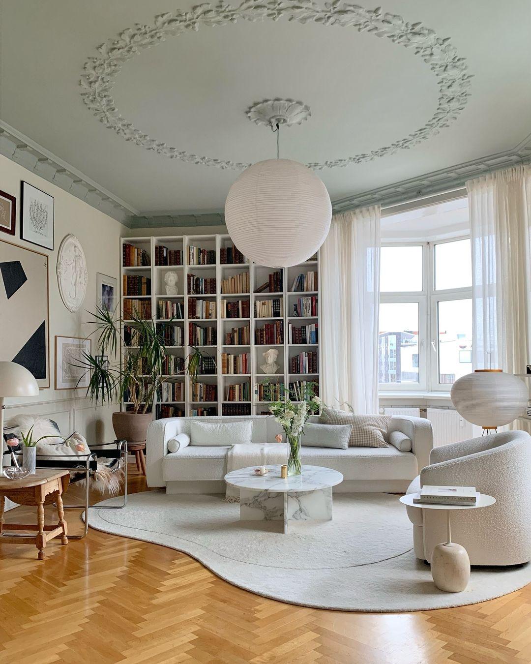White paper globe pendant light hanging above a furnished living or dining space