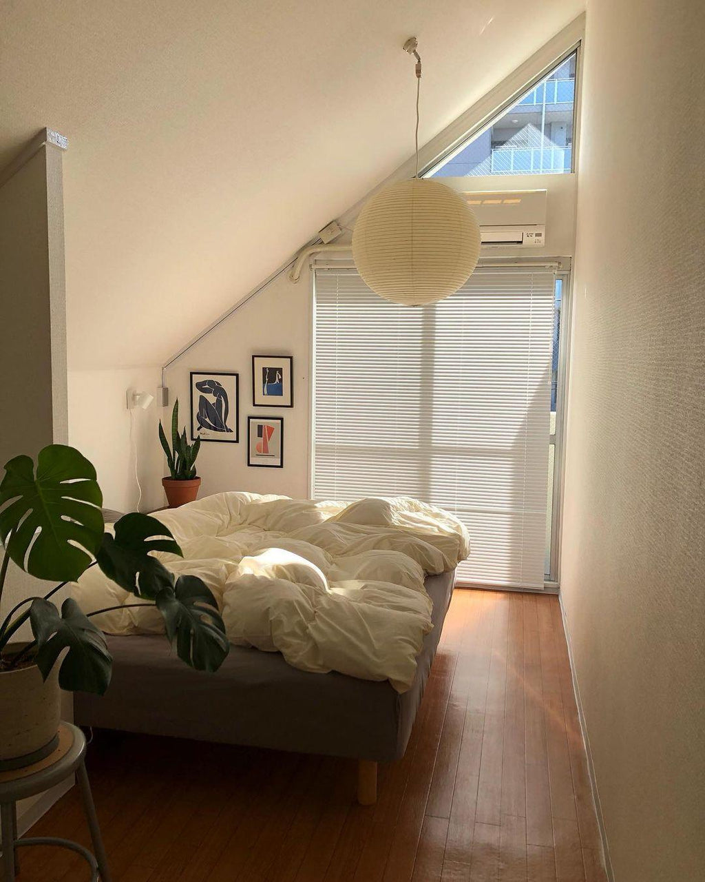 White paper globe pendant light hanging above a furnished living or dining space