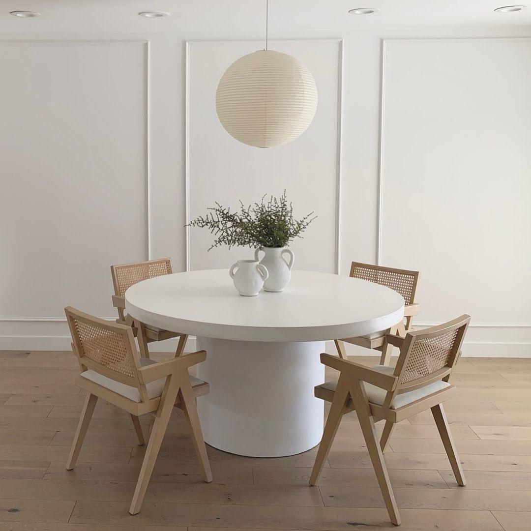 White paper globe pendant light hanging above a furnished living or dining space