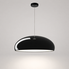 Black dome pendant light with a white inner shade hanging from a thin cord on a neutral background.