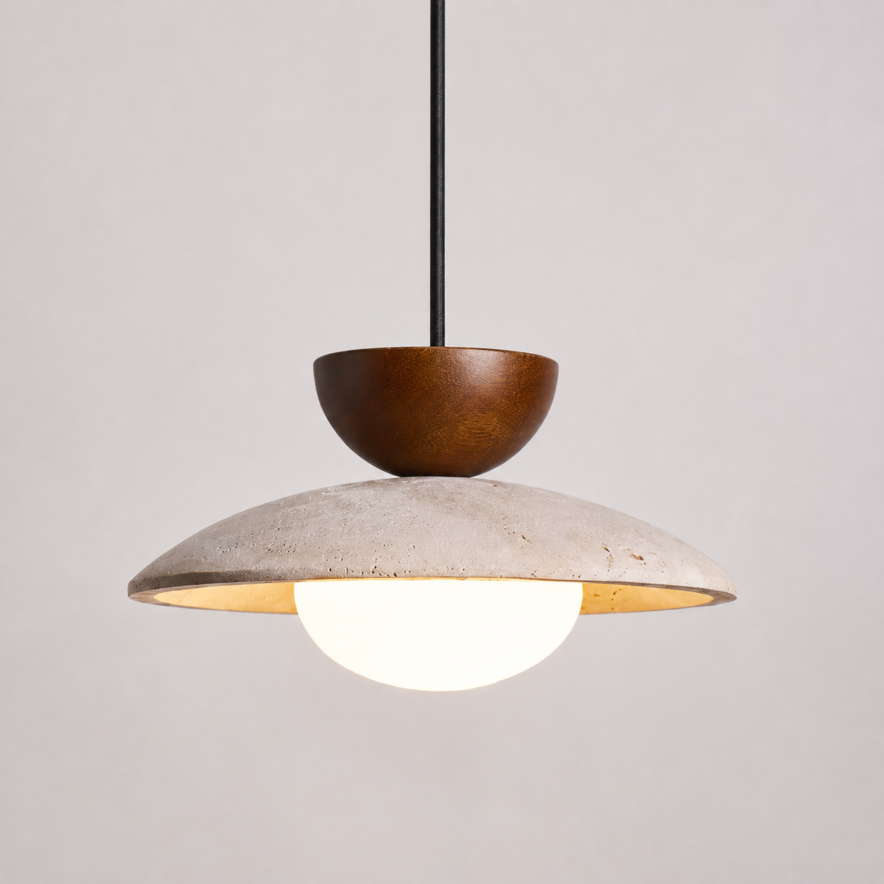 Pendant light with a wood accent, textured dome shade, and glowing round diffuser on a neutral background.