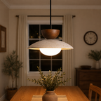 Pendant light suspended above a small table in a warm dining room.