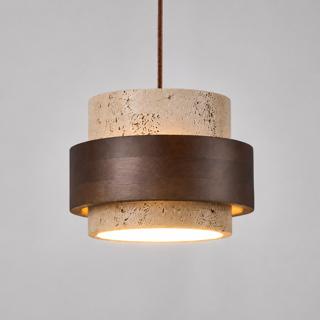 Pendant light with a round travertine and dark wood shade hanging against a light background with the light turned on.