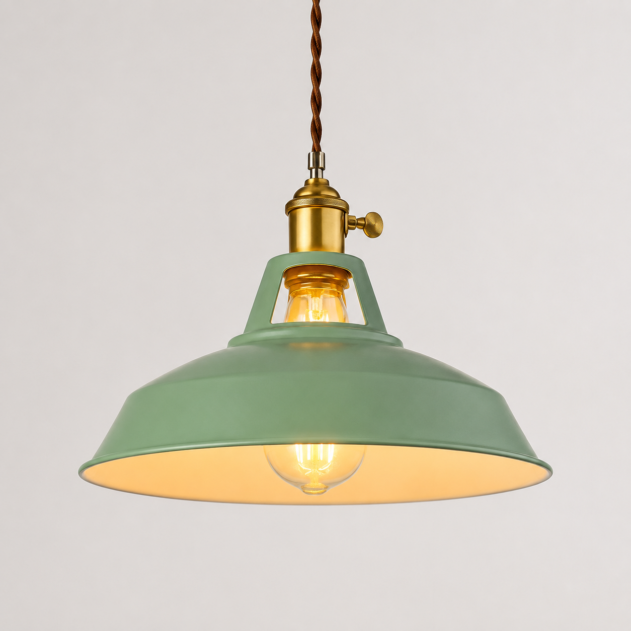 Metal pendant light with a brass socket, twisted brown cord, and exposed warm-glowing bulb.