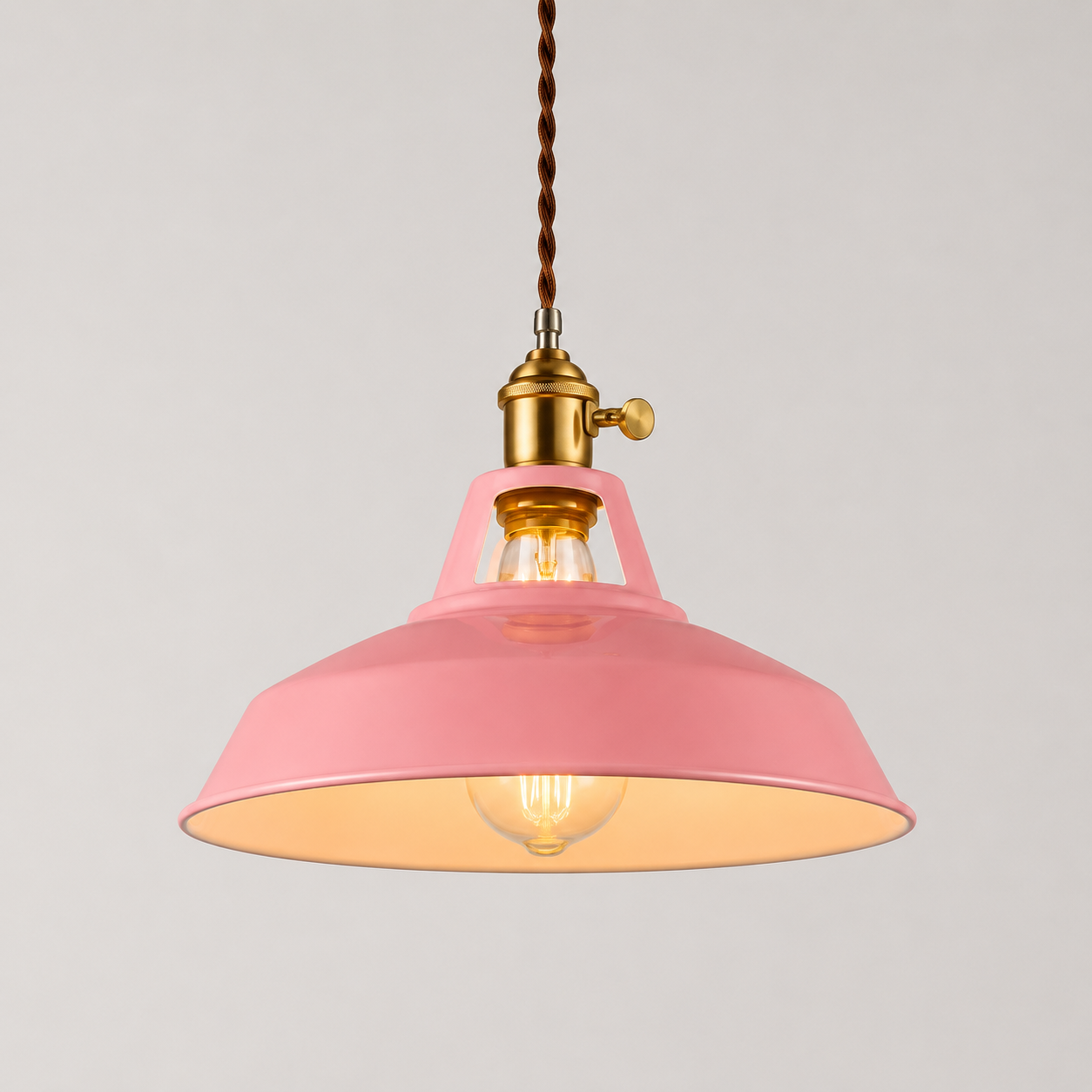 Metal pendant light with a brass socket, twisted brown cord, and exposed warm-glowing bulb.
