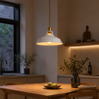 Metal pendant light with a brass socket, twisted brown cord, and exposed warm-glowing bulb.
