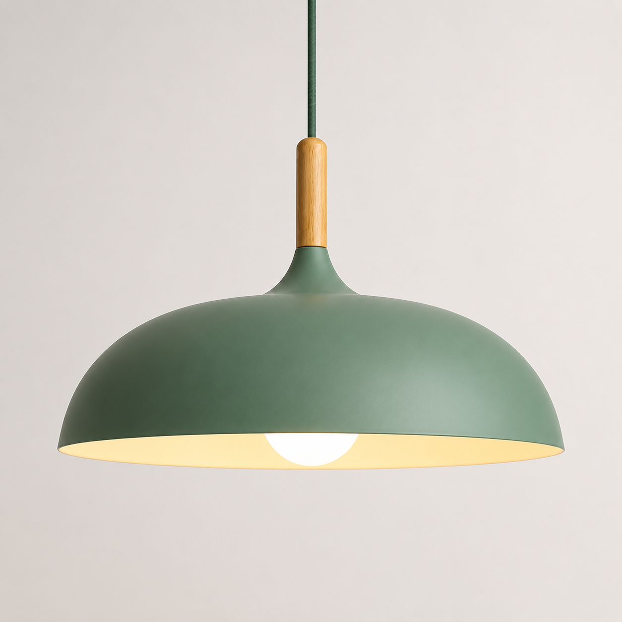 Green wide-dome pendant light with a natural wood stem, glowing warm white against a neutral background.
