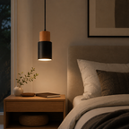 Pendant light hanging above a bedside table in a tidy bedroom with directed downward lighting.