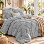 Light gray pinch pleat comforter set on a bed