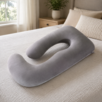 Gray U shaped pregnancy pillow displayed on a contemporary bed.