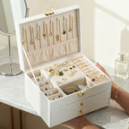 Open white jewelry box showing necklace hooks and removable trays