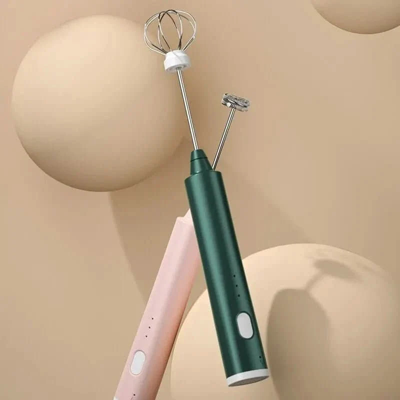 Green rechargeable hand mixer beside coffee and cake