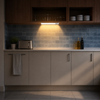 White motion sensor light illuminating a blue-gray kitchen backsplash
