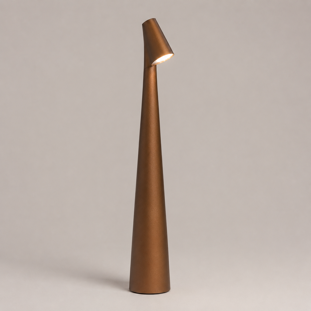 Golden brown table lamp with a tall tapered body and angled head on a neutral studio background.