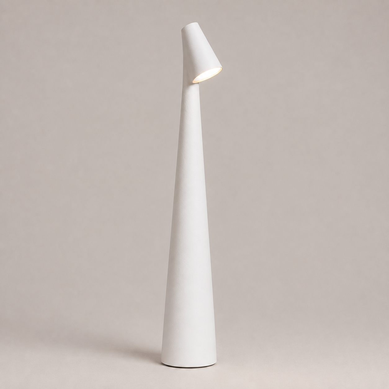 White table lamp with a tapered cone body and angled light head on a neutral studio background.