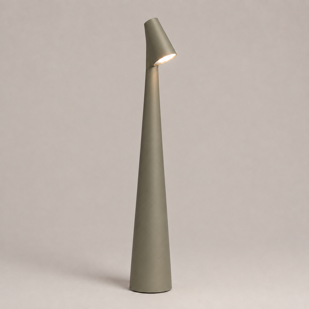 Silver table lamp with a tapered cone body and angled light head on a neutral studio background.