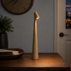 Golden brown table lamp glowing on a dark console near a wall clock and closed door.