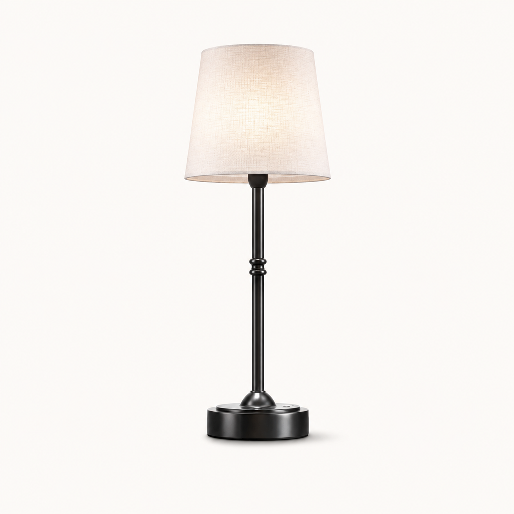 A modern table lamp with a tapered off-white fabric shade, a slim black metal stem with decorative bead details, and a round black base, shown against a plain off-white background.