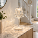 Glowing table lamp on a bright kitchen counter beside a staircase, casting patterned light on nearby surfaces.