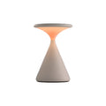 White rechargeable table lamp with a conical base and glowing disc shade.