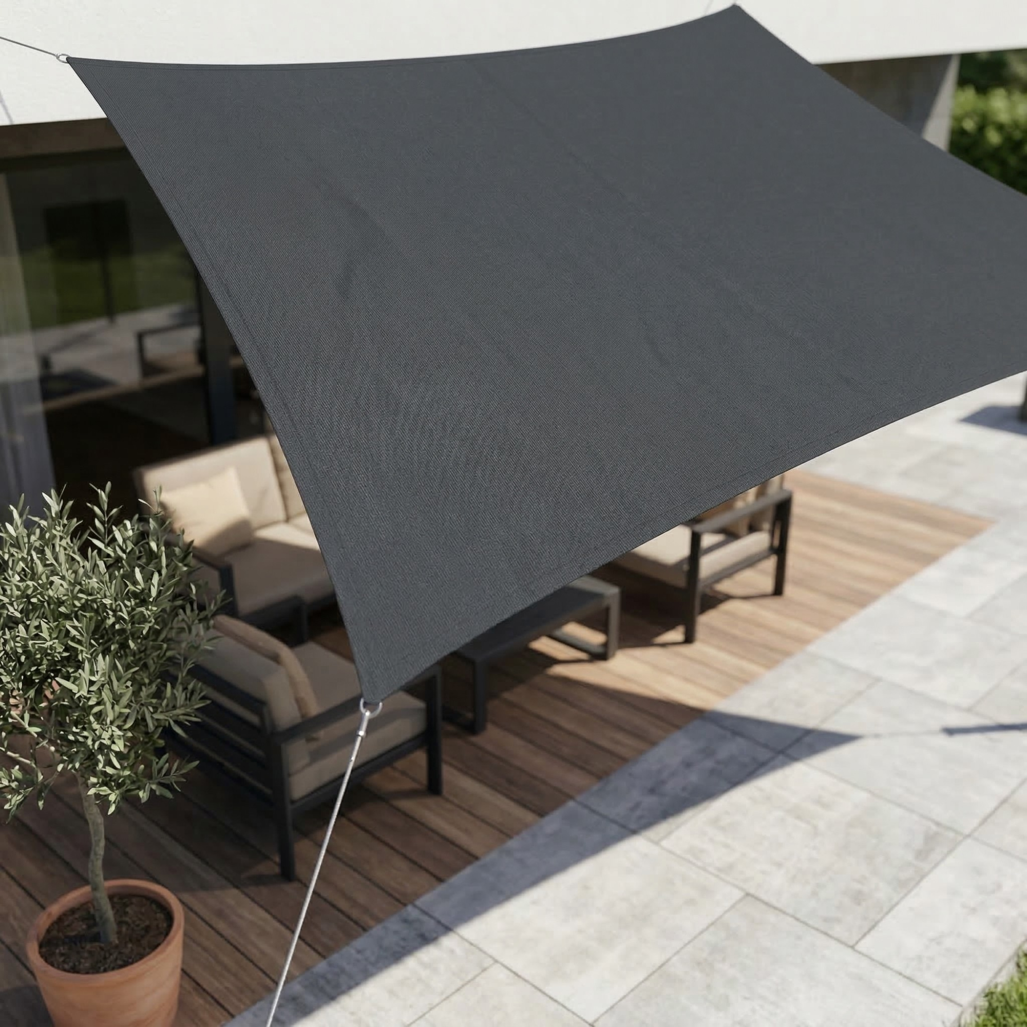 Dark gray rectangular shade sail stretched above a patio table.