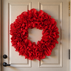 Red decorative ruffle wreath displayed on a pale door