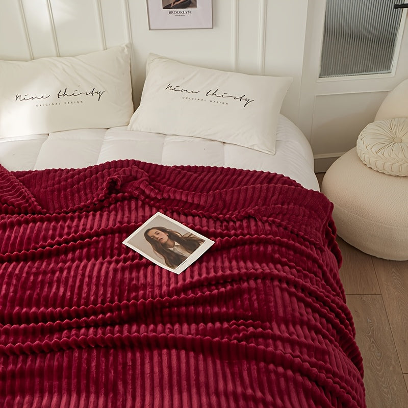 Burgundy plush throw folded back on a bed
