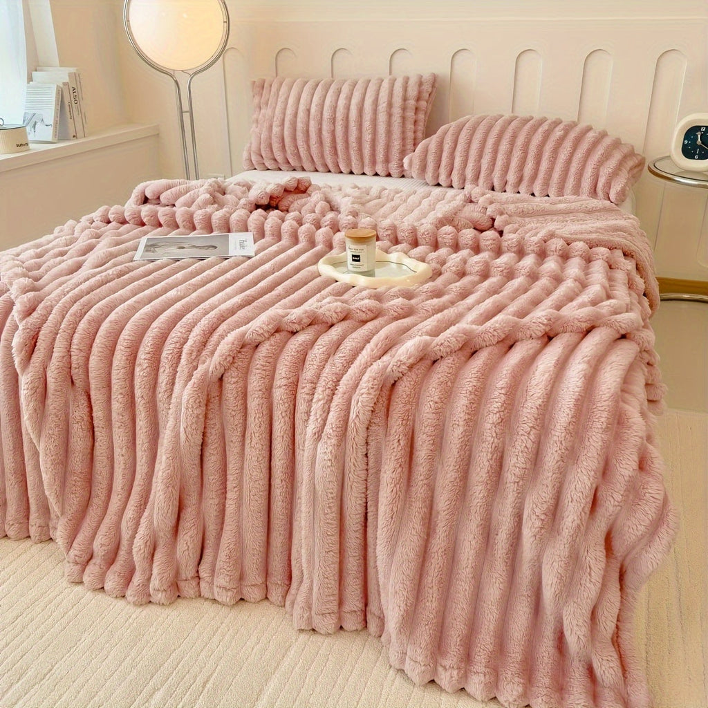 Pink broad ribbed blanket on a bed