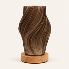 A sculptural brown wooden lamp or vase with a wavy, ribbed texture, resting on a round light wood base against a plain off-white background.